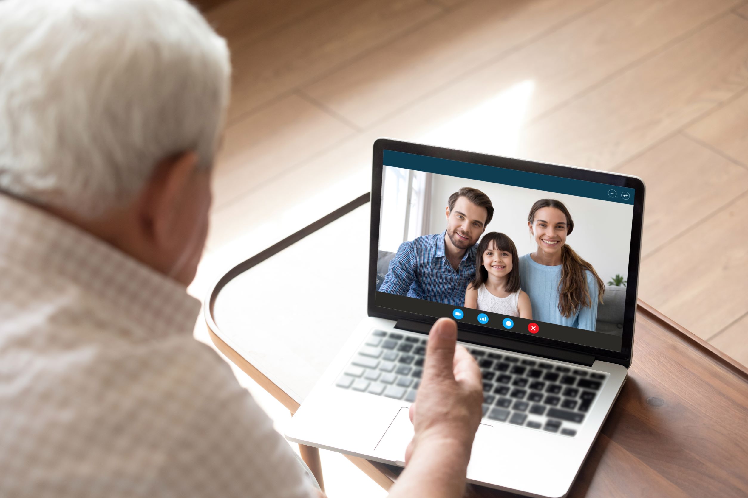 Elderly man on laptop with family